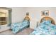 Bright bedroom with two twin beds, featuring blue and white bedding at 4783 Cumbrian Lakes Dr, Kissimmee, FL 34746