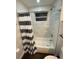 Bathroom with tub/shower, marble tile walls, and striped shower curtain at 8711 Rockingham Ter # D, Kissimmee, FL 34747