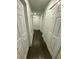 Hallway with several white doors and dark wood-look flooring at 8711 Rockingham Ter # D, Kissimmee, FL 34747