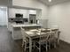Open-concept kitchen and dining area with white cabinetry, stainless steel appliances, and ample seating at 8711 Rockingham Ter # D, Kissimmee, FL 34747