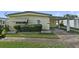 Quaint yellow mobile home with covered carport at 115 Palm Dr, Eustis, FL 32726