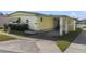 Mobile home with carport and mature shrubs at 115 Palm Dr, Eustis, FL 32726