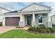 One-story home with gray stone accents and a brown garage door at 2813 Willowseed Ln, St Cloud, FL 34772