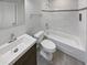 Clean bathroom boasts a white vanity, toilet, and bathtub with tile surround at 3063 Cayman Way, Orlando, FL 32812