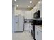 White kitchen with black appliances and granite counters at 3300 Whitestone Cir # 306, Kissimmee, FL 34741