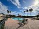 Inviting community pool with lounge chairs and palm trees at 3300 Whitestone Cir # 306, Kissimmee, FL 34741