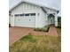 Two-car garage and light-colored house with a landscaped yard at 5031 Dancy Ln, St Cloud, FL 34772