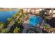 Resort-style pool with sundeck, surrounded by lush landscaping and lake at 8001 Cool Breeze Dr # 121, Orlando, FL 32819