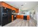 Modern kitchen with wood cabinets, black appliances, and breakfast bar at 8001 Cool Breeze Dr # 121, Orlando, FL 32819
