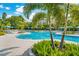 Expansive pool area with turquoise water, palm trees and blue umbrellas at 8001 Cool Breeze Dr # 121, Orlando, FL 32819