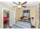 Bedroom with blue and white striped bedding, wood floors, and ceiling fan, with view of living area at 1413 Dorothy Ave, Haines City, FL 33844