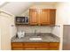 Compact kitchen with granite countertops, microwave, and wooden cabinets at 1413 Dorothy Ave, Haines City, FL 33844
