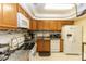 Kitchen with wood cabinets, white appliances, and granite countertops at 1413 Dorothy Ave, Haines City, FL 33844