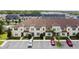 An aerial view showcasing a row of townhouses with parking spaces and landscaping at 1567 Carey Palm Cir, Kissimmee, FL 34747