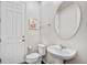 Clean and bright half-bathroom with a pedestal sink and oval mirror at 1567 Carey Palm Cir, Kissimmee, FL 34747