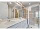 Modern bathroom with double sinks, a glass shower, and tiled walls at 1567 Carey Palm Cir, Kissimmee, FL 34747