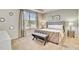 Cozy bedroom with a tufted headboard, bench, and large window at 1567 Carey Palm Cir, Kissimmee, FL 34747