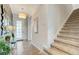 Welcoming foyer with decorative mirror, entry table, and carpeted stairs at 1567 Carey Palm Cir, Kissimmee, FL 34747