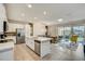 Modern open-concept kitchen and living area with white cabinets, island, and stainless steel appliances at 1567 Carey Palm Cir, Kissimmee, FL 34747