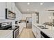 Modern white kitchen with stainless steel appliances and ample counter space at 1567 Carey Palm Cir, Kissimmee, FL 34747