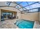 Backyard oasis featuring a screened-in pool, patio furniture, and grilling area at 1567 Carey Palm Cir, Kissimmee, FL 34747