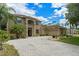 Two-story home with a paved driveway, lush landscaping, and palm trees at 2307 Treetop Ln, Kissimmee, FL 34746