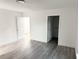 Empty bedroom with gray wood-look flooring, white walls, and access to a bathroom at 2449 Sunset Dr, Lake Wales, FL 33898