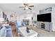 Living room with blue sofa, entertainment center, and view of the dining area and kitchen at 2967 S Atlantic Ave # 504, Daytona Beach Shores, FL 32118