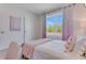 Bright bedroom with large window and soft pink accents at 3528 Sandalwood Isle Way, Ocoee, FL 34761