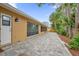 Paved backyard patio with a landscaped border and palm trees at 3966 Lake Mira Dr, Orlando, FL 32817