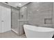 Contemporary bathroom with a freestanding tub, glass shower, and gray tiled walls at 3966 Lake Mira Dr, Orlando, FL 32817