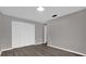Empty bedroom featuring white closet doors and wood-look laminate flooring at 3966 Lake Mira Dr, Orlando, FL 32817
