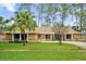 Single-story home with a tan exterior, green front door, and landscaped yard at 3966 Lake Mira Dr, Orlando, FL 32817
