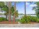 View of a lake from a backyard with palm trees and pine trees at 3966 Lake Mira Dr, Orlando, FL 32817