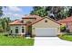 Charming single-story home with tile roof, white garage door, and landscaped yard at 5 Forest Ln, Eustis, FL 32726