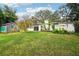 Spacious backyard with lush green grass, trees, and a storage shed at 5024 Saint Germain Ave, Belle Isle, FL 32812