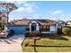 House with a blue garage door, landscaping, and a driveway at 532 Maricopa Dr, Kissimmee, FL 34758