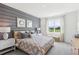 Spacious main bedroom with patterned bedding, wood accent wall, and large window at 5928 Cliffbow Loop, Leesburg, FL 34748