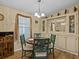 Dining area with round table, green chairs, and built-in hutch with mirror at 707 Coachman Dr, Leesburg, FL 34748