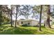 Backyard view of the single-story house nestled among green trees and lawn at 1469 Swan Pl, Kissimmee, FL 34759