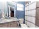 Guest bathroom boasts granite countertops and wooden cabinetry, alongside a tiled shower/tub combo at 1469 Swan Pl, Kissimmee, FL 34759