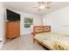 Simple bedroom with tile floor, ceiling fan, and wooden furniture at 1469 Swan Pl, Kissimmee, FL 34759