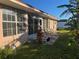 Relaxing backyard patio featuring a lush green lawn and tropical plants at 207 Fairgreen Ave, New Smyrna Beach, FL 32168