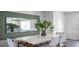Dining area with a white table, woven chairs, and a large mirror on a green accent wall at 2765 Flushing Dr, Apopka, FL 32703
