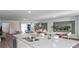 View of the kitchen island with granite countertop, double sink, and view into the open living and dining area at 2765 Flushing Dr, Apopka, FL 32703