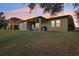 Backyard of a home with a covered patio, outdoor furniture, grill, and a large lawn at 2920 Orangebud Dr, Kissimmee, FL 34746