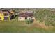 Backyard view of a house with a covered patio, grill, and lush green lawn at 2920 Orangebud Dr, Kissimmee, FL 34746