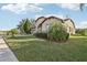 Exterior view of a house with a landscaped yard, palm trees, and a driveway at 2920 Orangebud Dr, Kissimmee, FL 34746