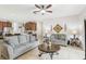 Living room with gray couches, decorative wall art, and ceiling fan, open to the kitchen at 2920 Orangebud Dr, Kissimmee, FL 34746