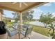 Covered patio with outdoor dining set, grill, and serene water view at 2920 Orangebud Dr, Kissimmee, FL 34746